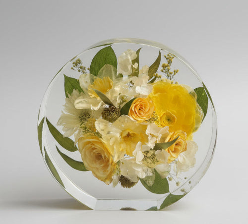 Round resin display with preserved yellow and white flowers on a reflective surface.